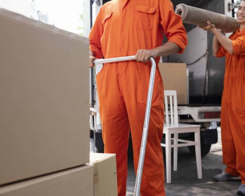 young-delivery-men-moving-objects-out-car