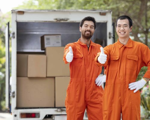 young-delivery-men-showing-ok-sign-near-delivery-car